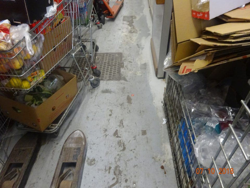 V zázemí (chodba pred skladmi) porušená celistvosť povrchovej úpravy podlahy