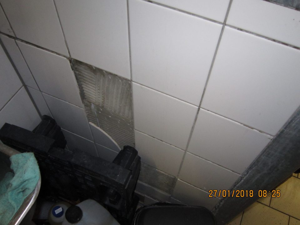 V priestore skladu určenom na čistiace a dezinfekčné prostriedky a čistiace pomôcky poškodený obklad.