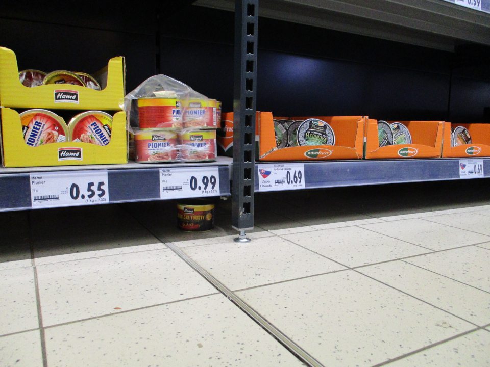 Znečistené podlahy pod regálmi a paletami na predajnej ploche.