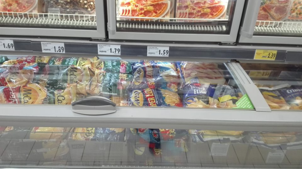 Mraziace zariadenia s blbokzmrazenými zemiakovými polotovarmi pod mriežkou znečistené prachom.