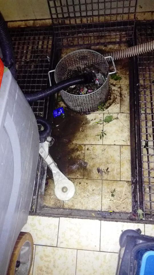 znečistená kanalizačná mriežka v časti skladu, určenom na skladovanie čistiacich pomôcok