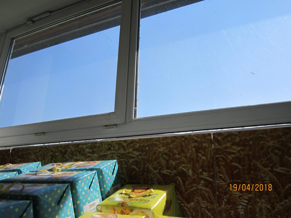 Okná na predajnej ploche znečistené, pokryté pavučinami.