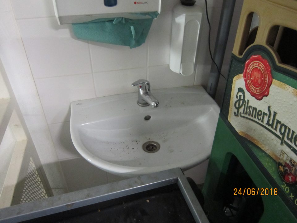 Znečistené a neprístupné umývadlo v manipulačnej chodbe pri príjmovej rampe.