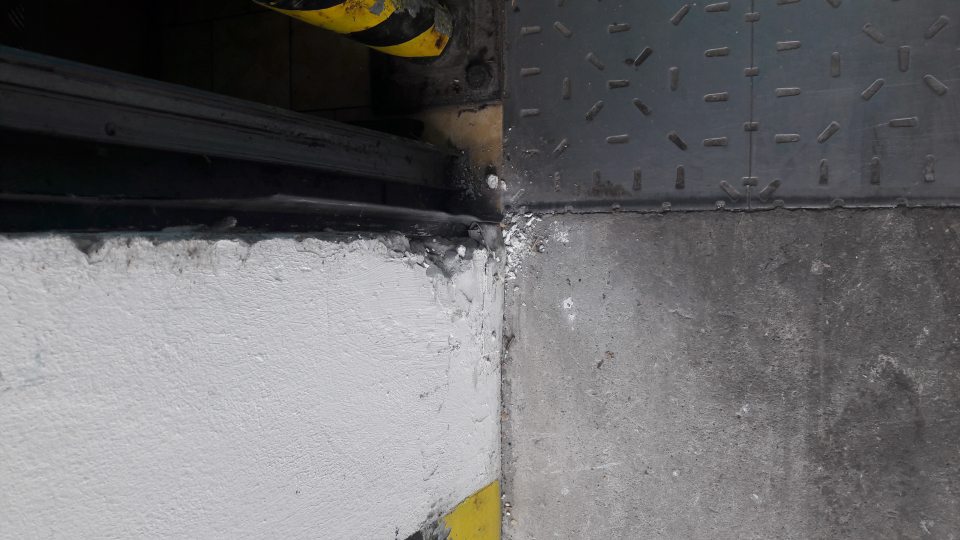 Poškodená stena nakladacej rampy v skladovacích priestoroch.