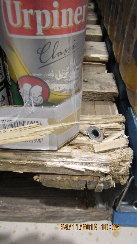 Značne poškodené drevené palety na predajnej ploche, na ktorých je uchovávané pivo. 