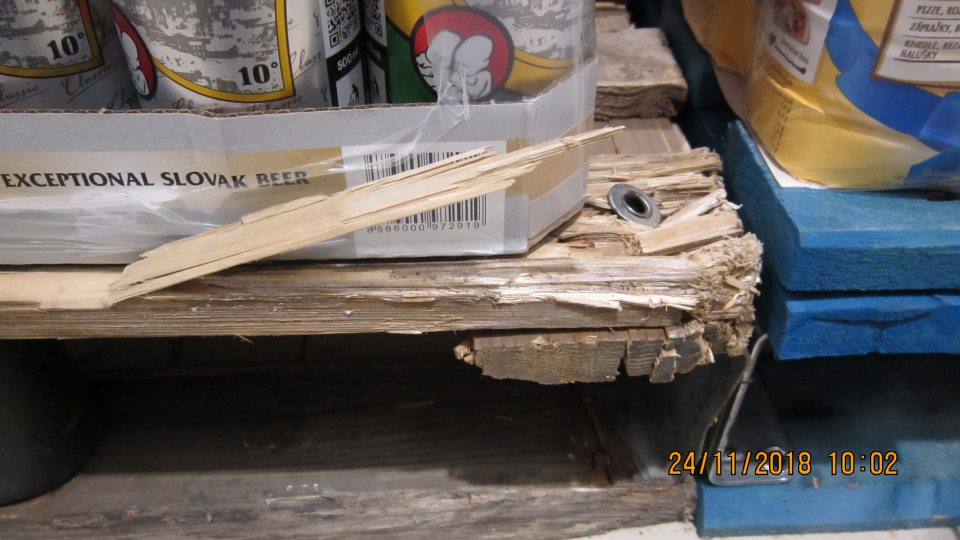 Poškodené drevené palety na predajnej ploche, na ktorých sú uchovávané potraviny.