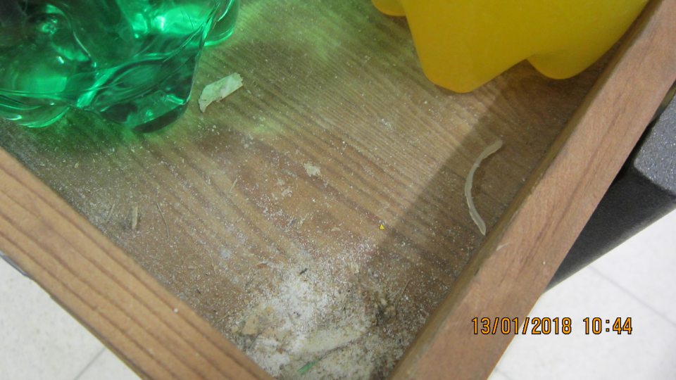 Na predajnej ploche znečistený stojan s umiestnenými nápojmi.