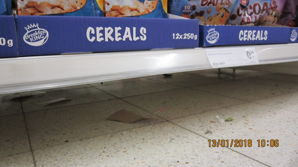 Na predajnej ploche znečistená podlaha pod regálom s cereáliami.