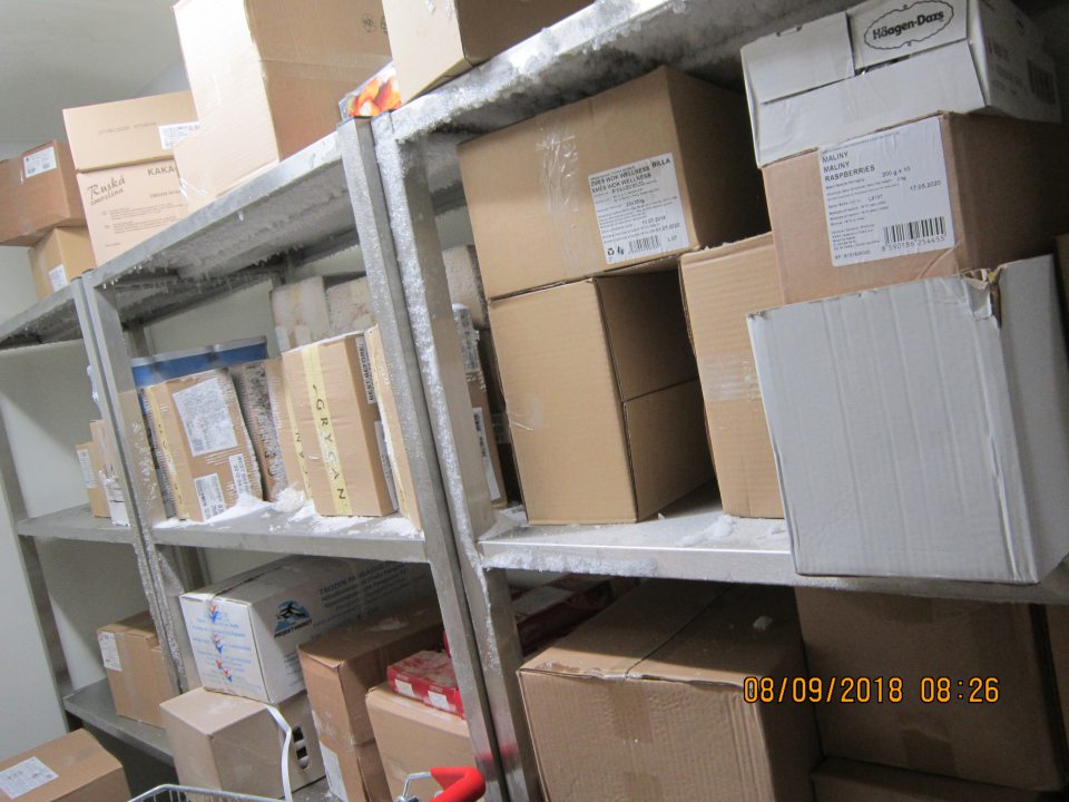 V zázemí prevádzky, v mraziacom boxe námraza na regáloch, na kartónoch s potravinami.