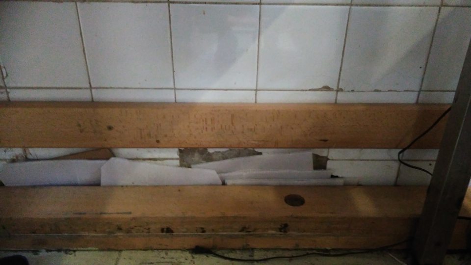 Poškodený obklad steny pri miestnosti Rozrábka mäsa.