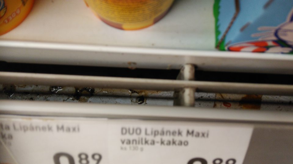 Znečistené ochranné mriežky a žľab pod mriežkami v prednej časti chladiacich vitrín na predajnej ploche