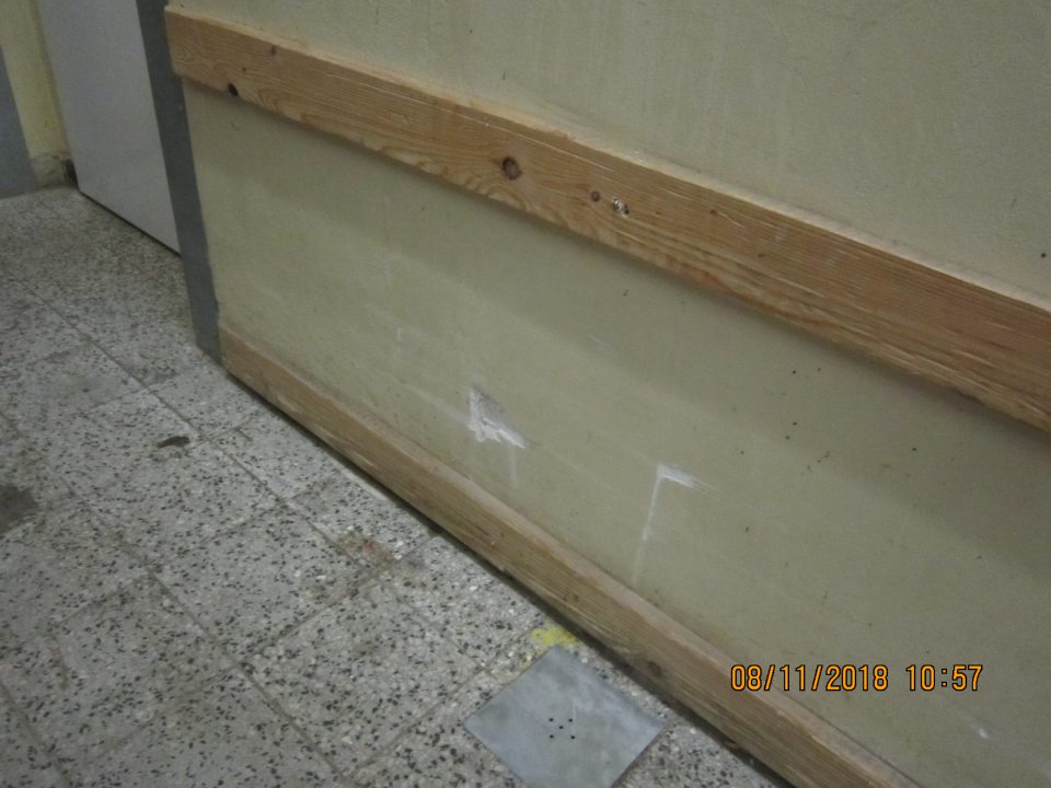 Poškodená stena, znečistená podlaha v skladovacích priestoroch. 