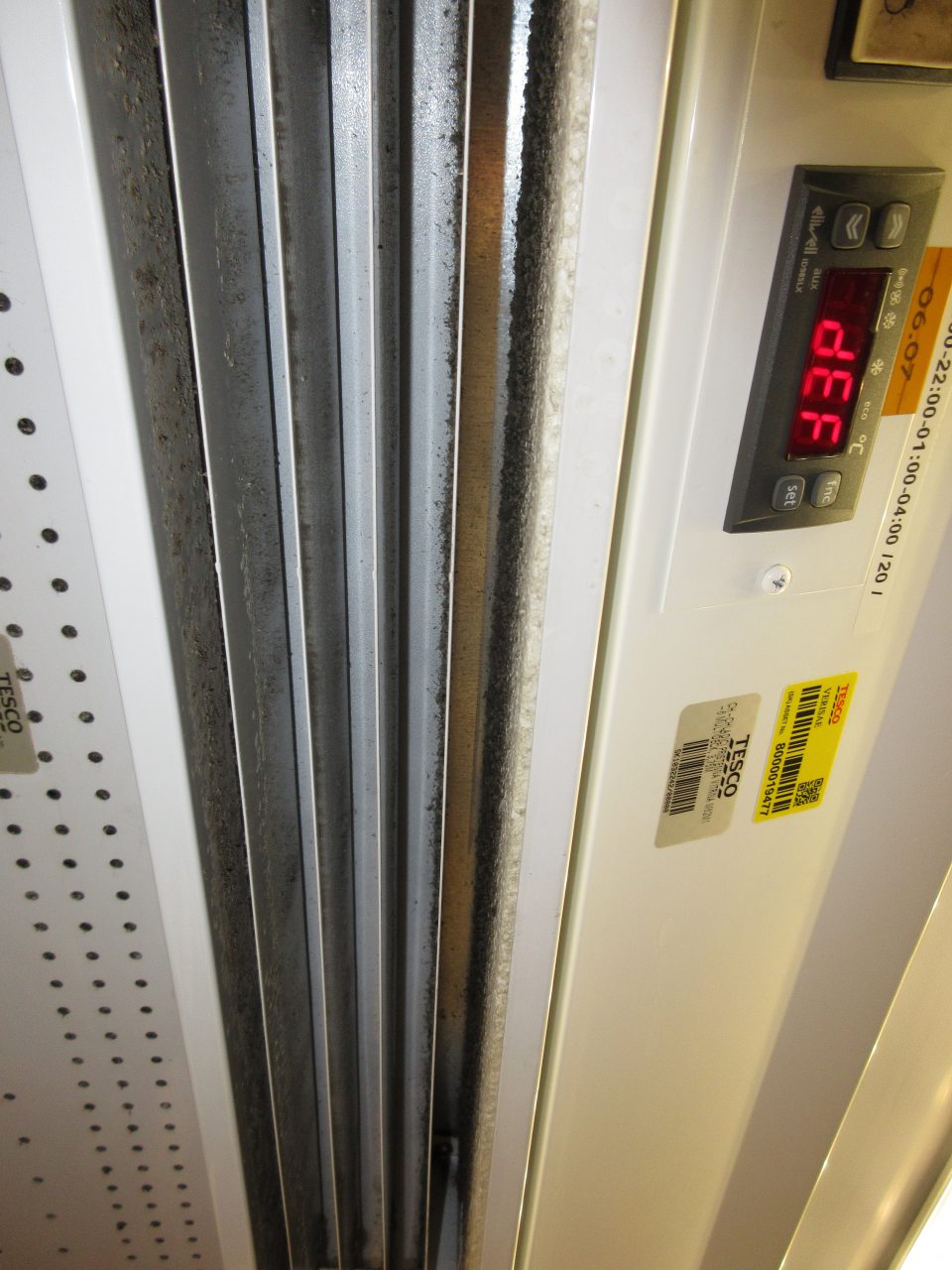 Chladiace vitríny na predajnej ploche pre mliečne výrobky, hydinové mäso sú znečistené prachom, porastom čiernej plesne v hornej časti vitríny medzi lištami a otvoroch vnútornej plochy.