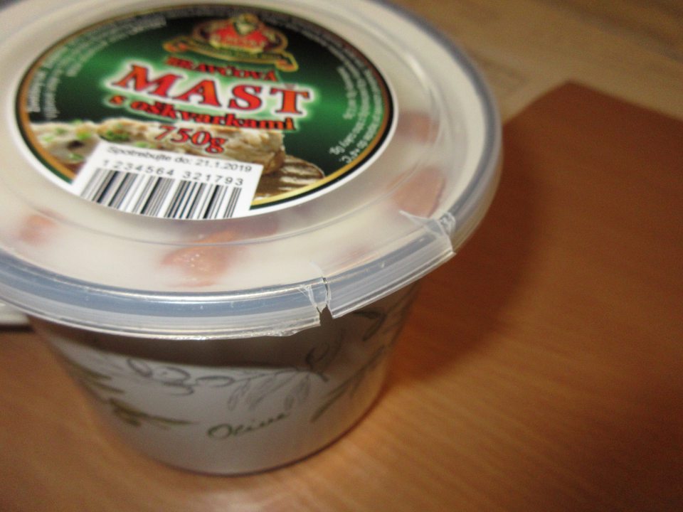 Poškodený obal- umelohmotné veko na kovovom hrnčeku na mäsovom výrobku.