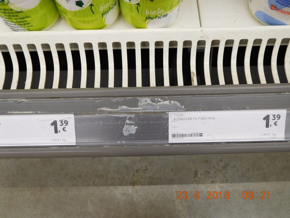 Znečistená plastová lišta prachom a potečenou tekutinou chladiacej vitríny na mliečne výrobky.