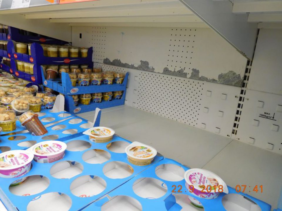 V priestore predajne na zadnej stene chladiacich zariadení na mliečne výrobky za potravinami na viacerých miestach zistené porušenie náterov,ich praskanie a opadávanie.