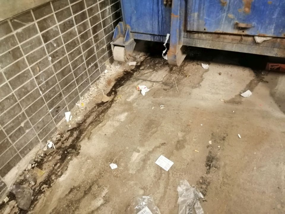 Zatečená a znečistená podlaha pod veľkokapacitným kontajnerom.