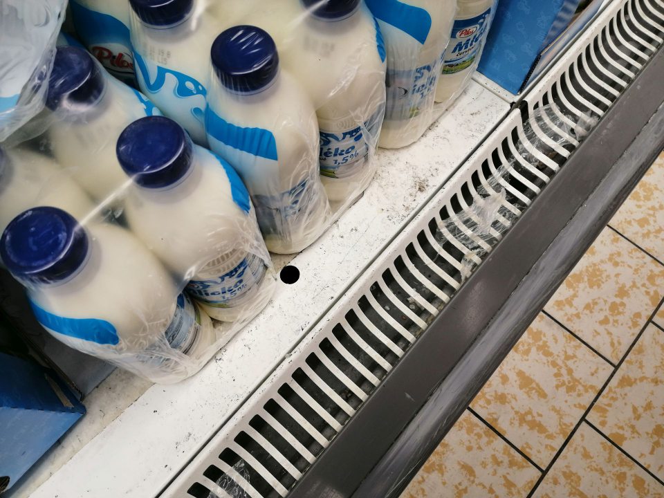 Znečistená polica regálu s mliekom.