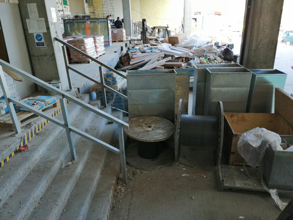 Príjmová rampa a celý vonkajší priestor vedúci k vnútornej časti príjmu potravín znečistený stavebným prachom s umiestneným stavebným materiálom.