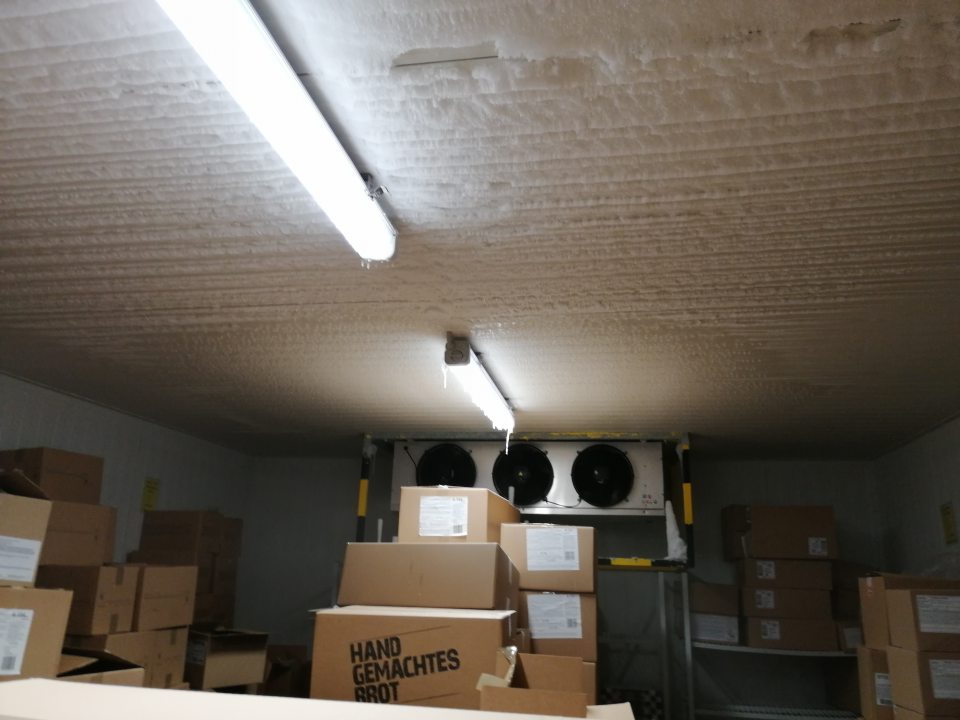 Námraza na strope, agregáte a svietidlách v mraziacom sklade pekárne.