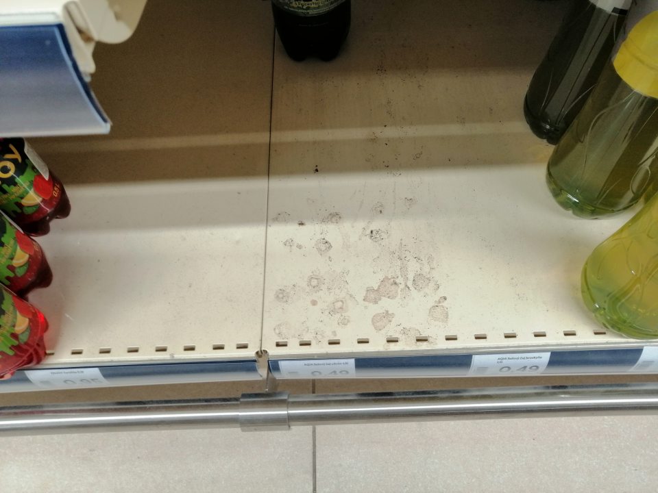 Znečistené police regálov na predajnej ploche.