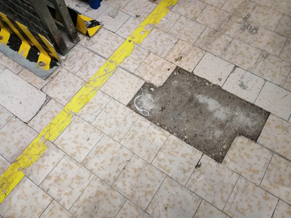 Znečistená a poškodená podlaha v suchom sklade.