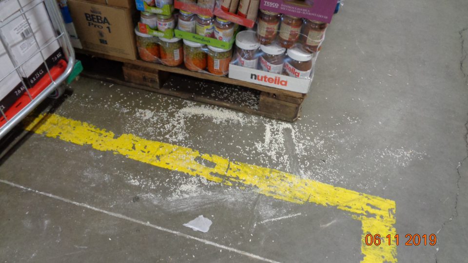 V blízkosti palety na uskladnenie ryže bola podlaha znečistená rozsypanou ryžou.