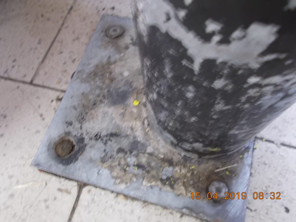 Znečistený ochranný stĺp proti narazeniu nánosom špiny.