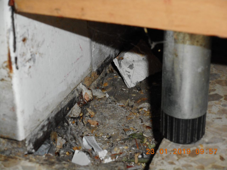 Poškodená podlaha s nečistotami.