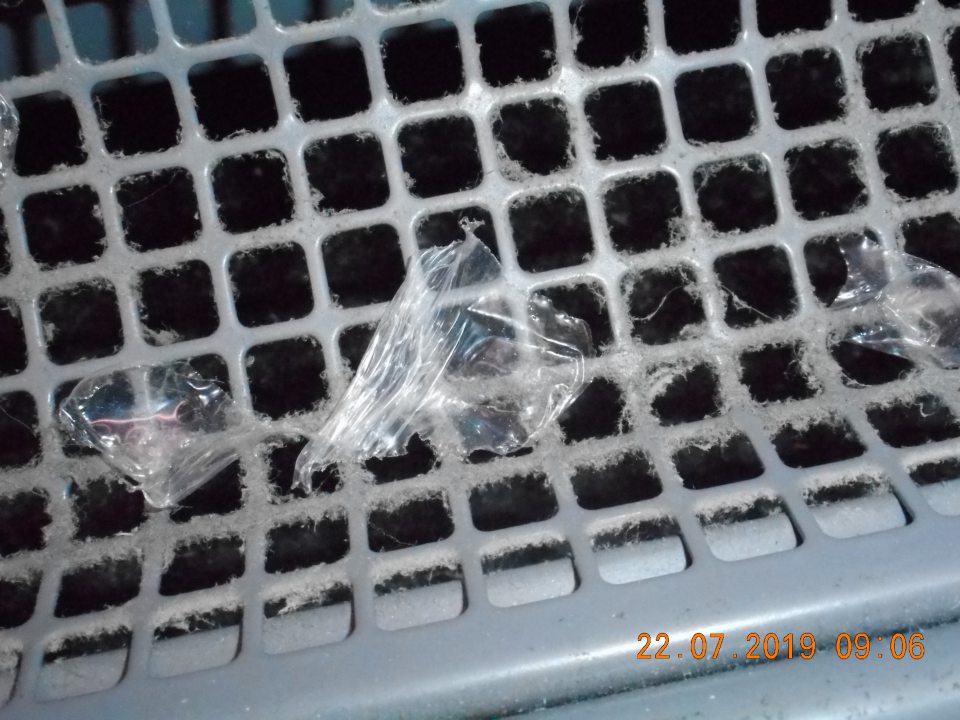 Znečistená mriežka na chladiacej vitríne určenej na predaj chladených nápojov.