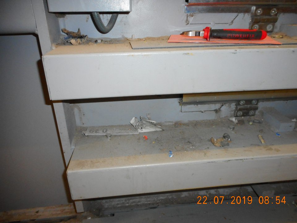 Znečistený lisovací stroj v skladovacích priestoroch.