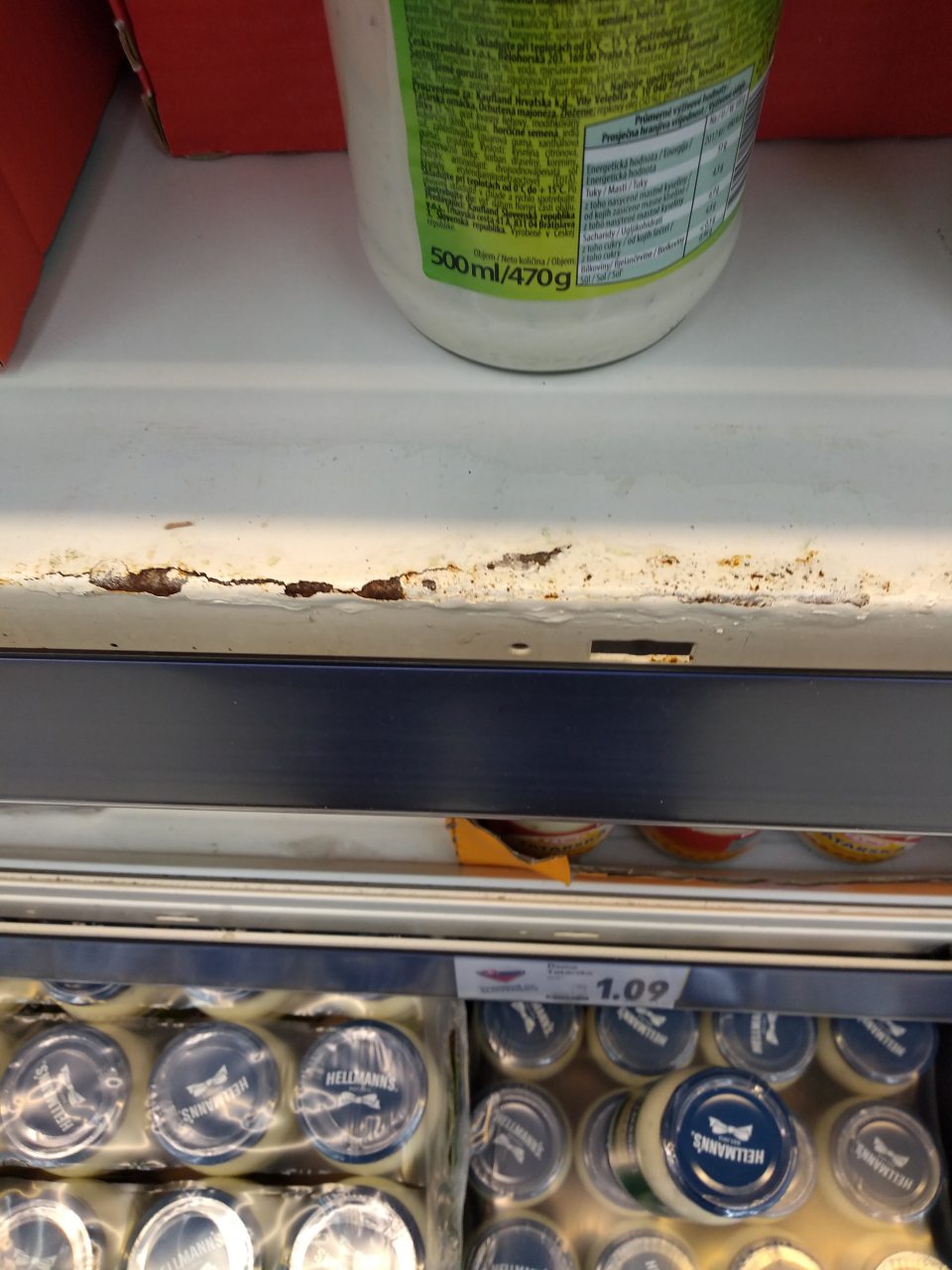 V chladiacej vitríne s uskladnenými majonézami - poškodené úložné regály s výskytom korózie.