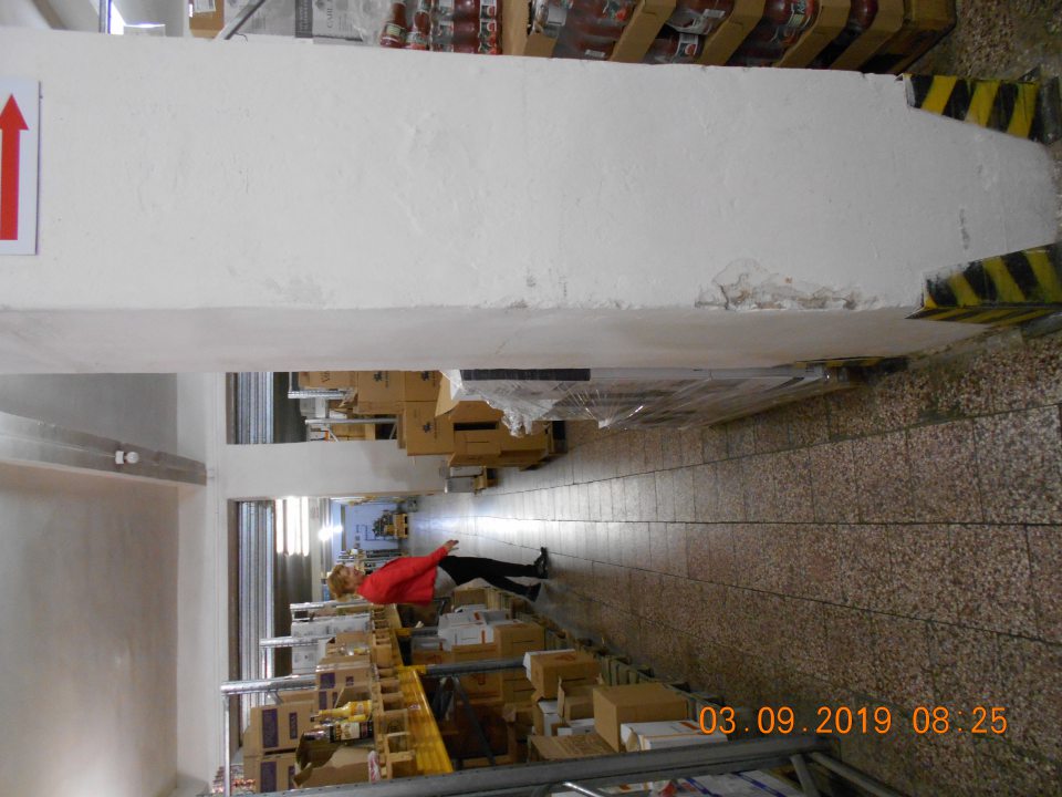 Poškodená stena na stlpoch pri regáloch s uloženými suchými potravinami.