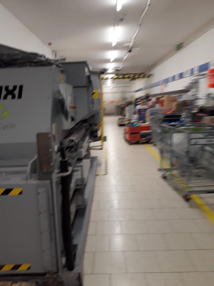 V zázemí v blízkosti vchodu do predajne je umiestnený lis na likvidáciu kartónov, ktorý nie je oddelený od priestoru skladovaných potravín.