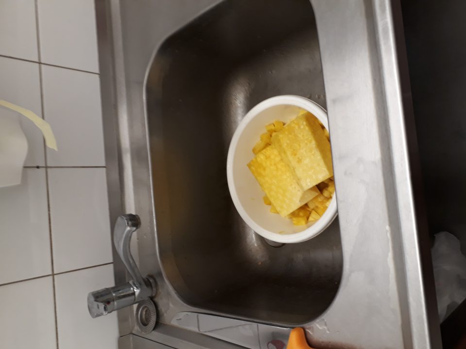 Ananás - surovina pre výrobu ovobaru uskladnený v plastovej nádobe skladovaný v nerezovom umývadle.