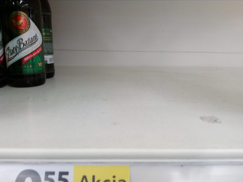 Znečistenie regálov na predajnej ploche na uchovávanie minerálnych vôd, pív, džúsov zaschnutou tekutinou a prachom.