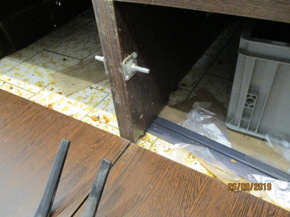 Znečistený priestor pod regálmi s nebalenými pekárskymi výrobkami.