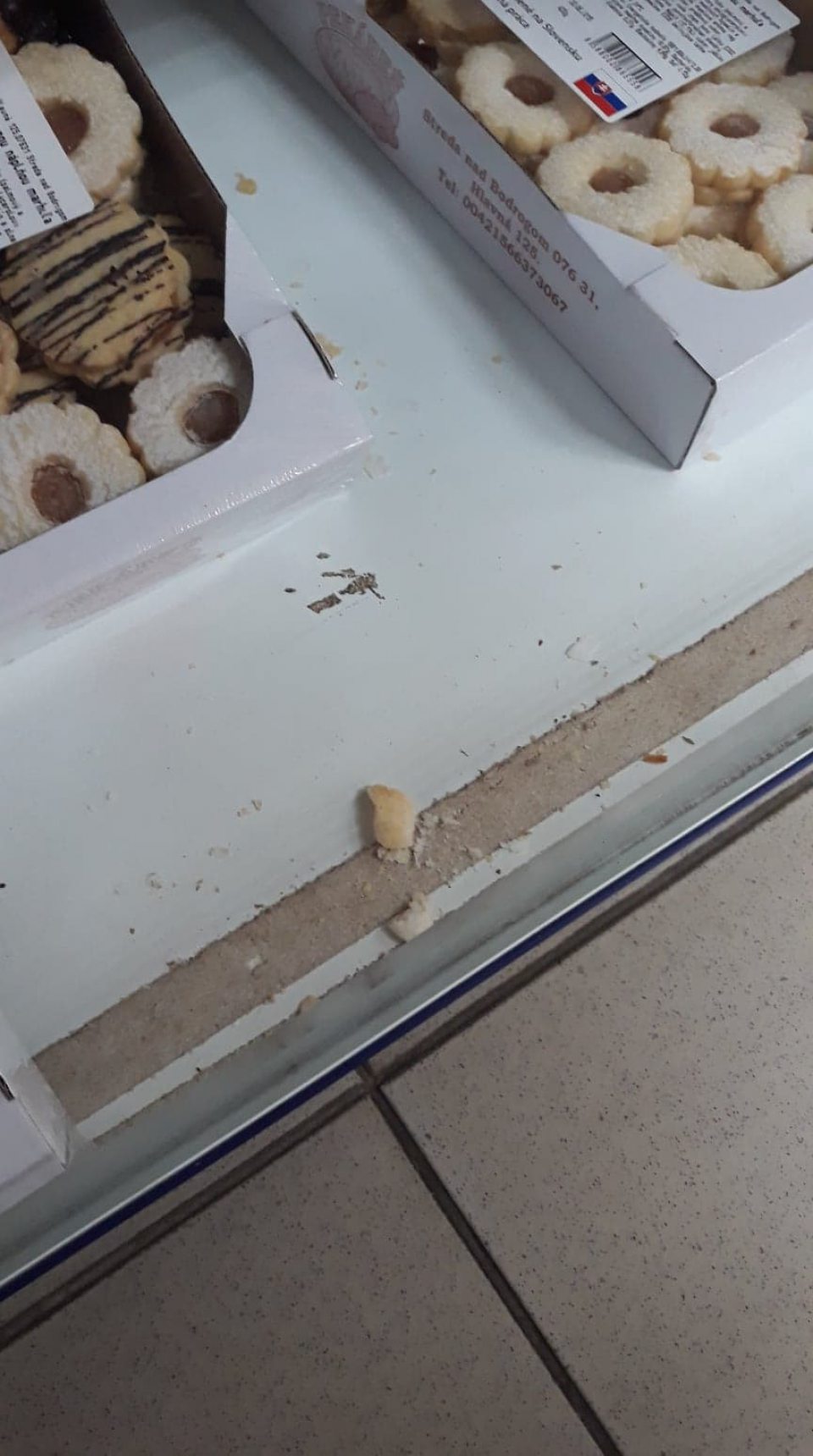 Znečistená polica regálu na predajnej ploche.