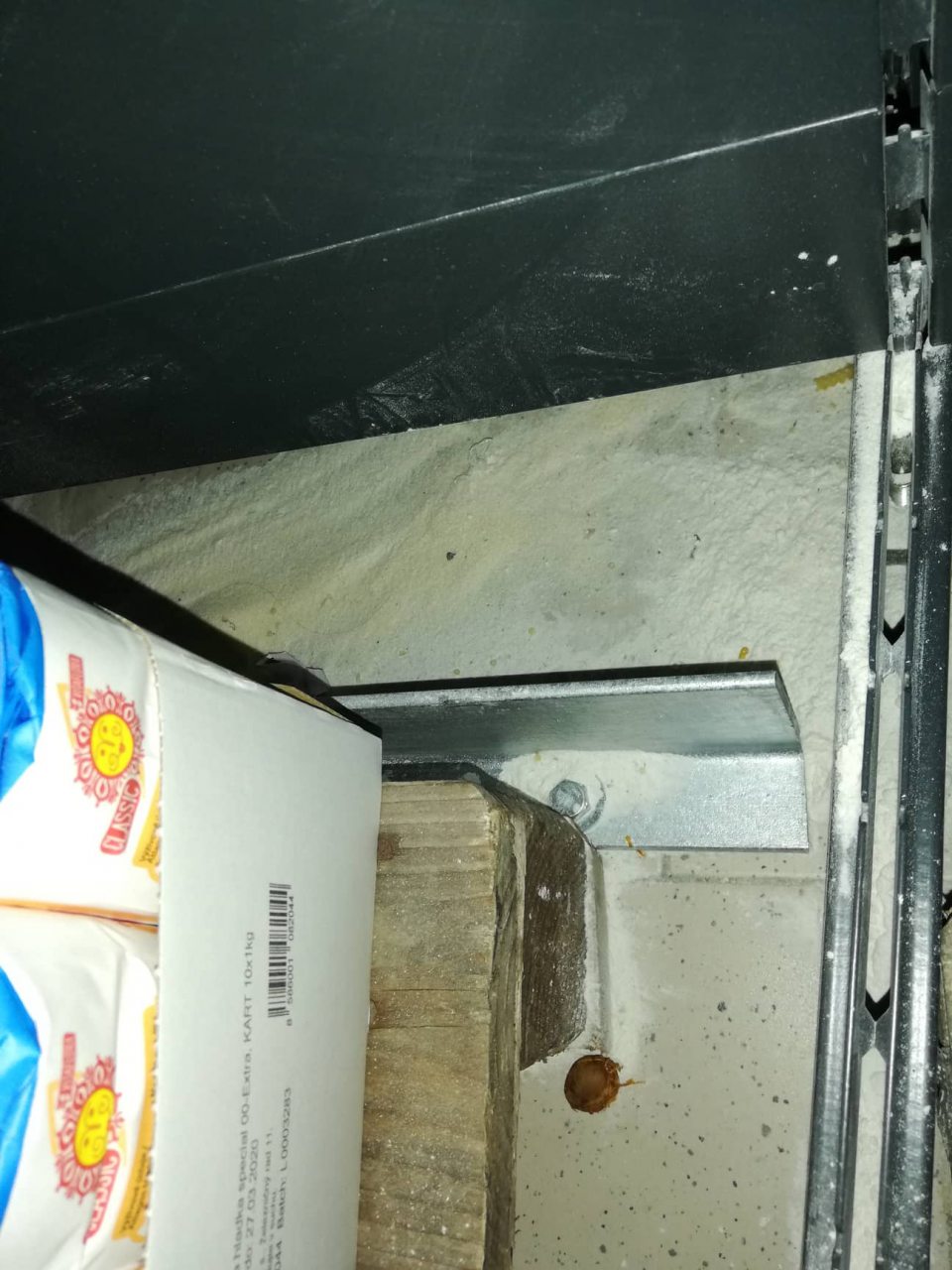 Pod regálmi na predajnej ploche znečistená podlaha potravinami.