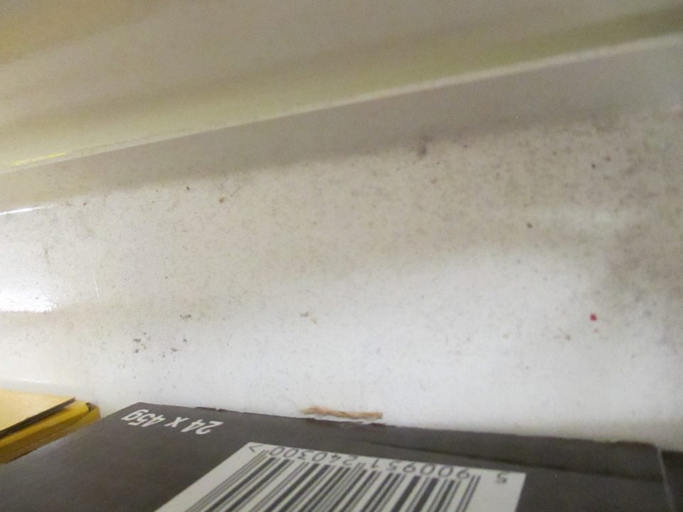 Regál s cukrovinkami pri pokladni č. 2 znečistený prachom a drobnými nečistotami.