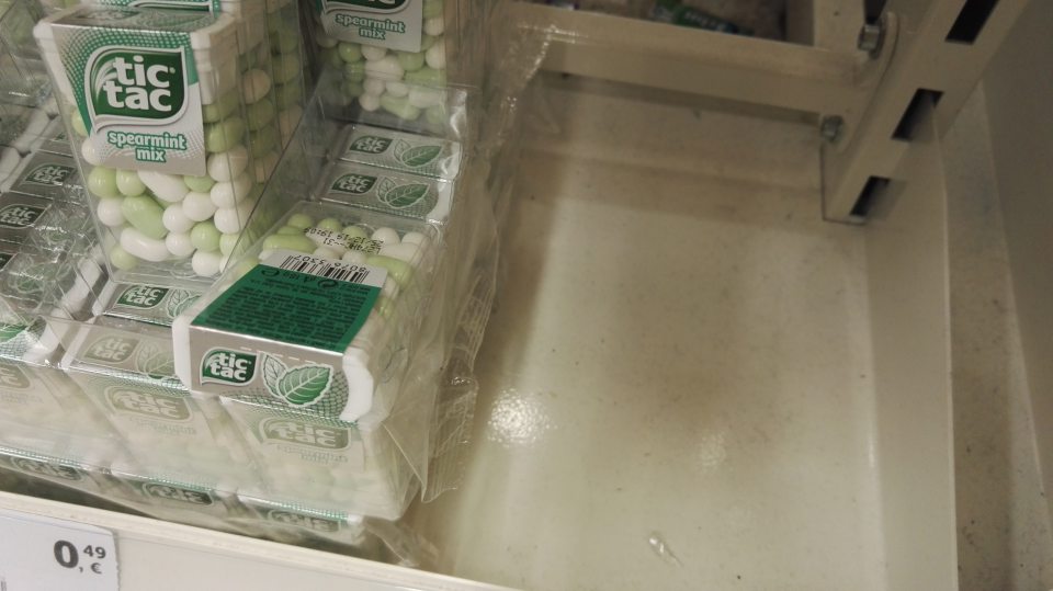 Regál s cukrovinkami pri pokladni č. 2 znečistený prachom a drobnými nečistotami.