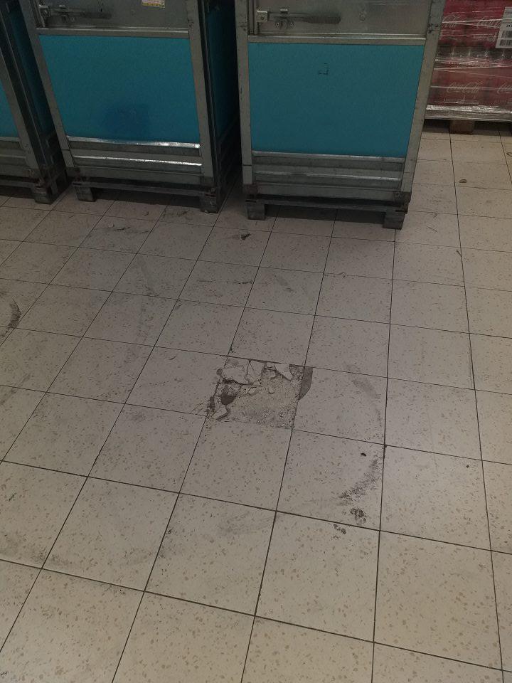 -Poškodená dlažba v príjmovej časti skladu potravín.