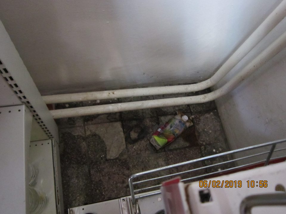 znečistená podlaha pri regáli.