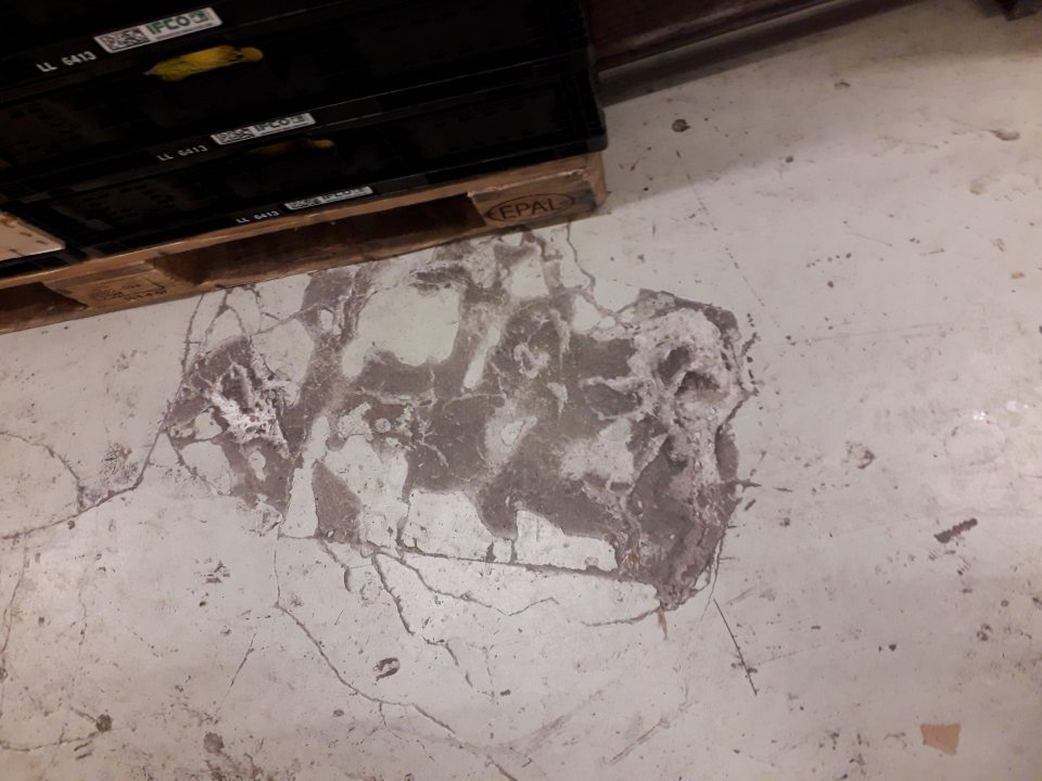 Poškodená, necelistvá podlaha v priestoroch skladu