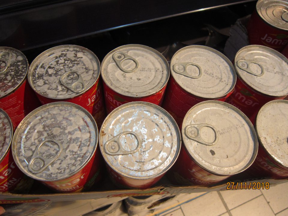 Predaj potraviny so znečisteným a zatečeným obalom, s počiatočnou koróziou.