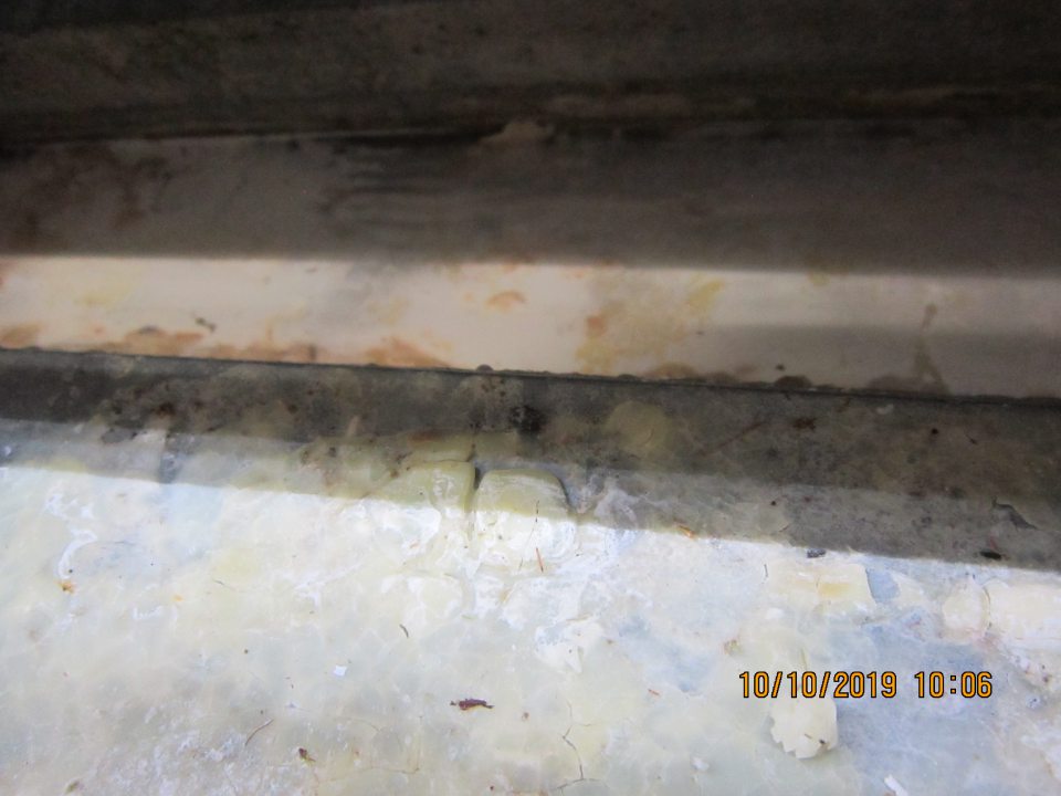 Na predajnej ploche v chladiacich vitrínach označených NK3 (vo vitrínach boli uložené mliečne výrobky, mlieko, vajíčka) bola zistená zatečená zaschnutá tekutina pod mriežkou a regálom na dne chladiacej vitríny