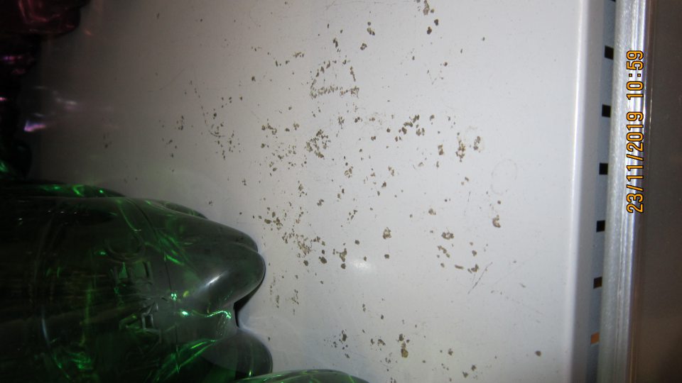 Na predajnej ploche na oddelení predaja nealkoholických nápojov znečistené police regálov.