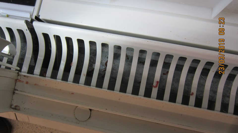 Na predajnej ploche v chladiacej vitríne znečistenie pod mriežkou a na zasúvacej lište posuvných dverí.  