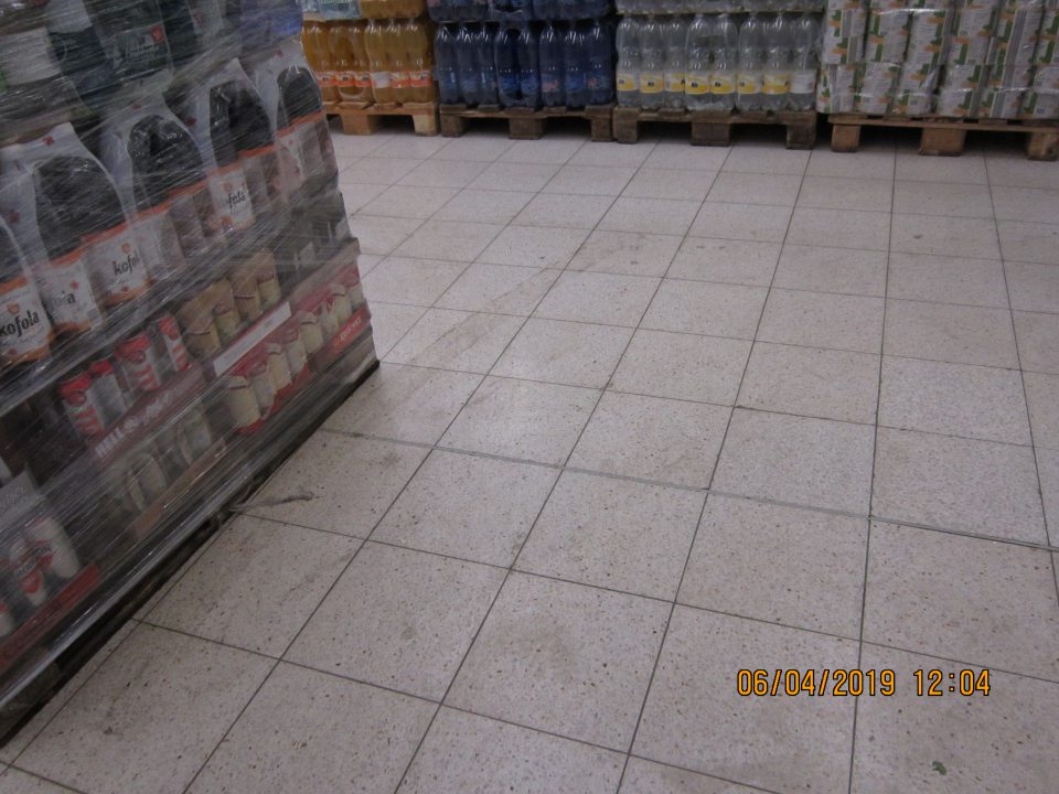 Na predajnej ploche znečistená podlaha tmavými zaschnutými škvrnami.