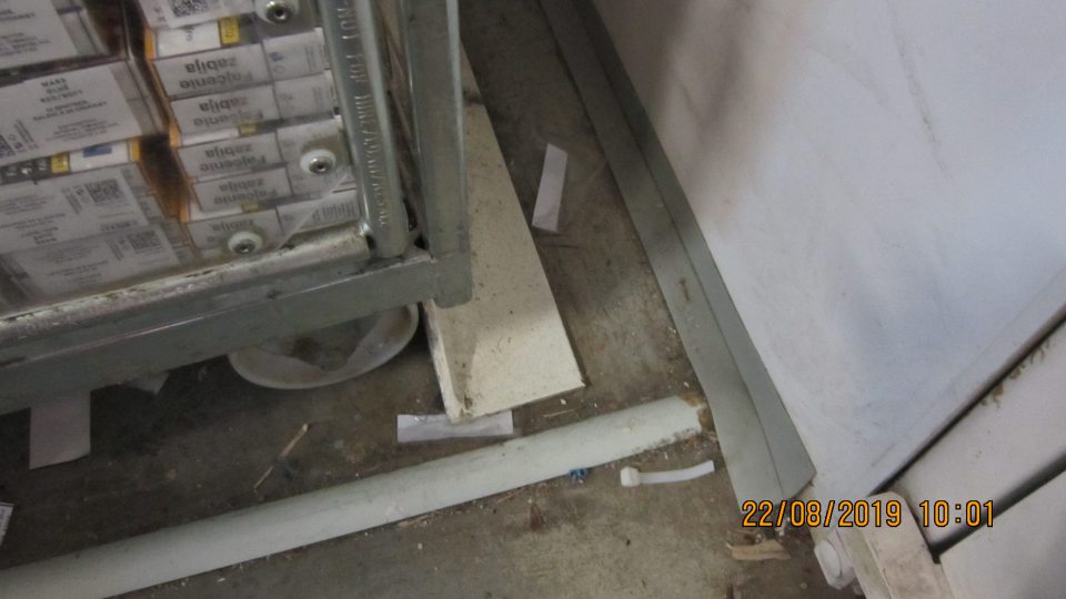 V zázemí pri vstupe z predajne, za dverami je znečistená podlaha od prachu, napadaných nečistôt, a obalov. 